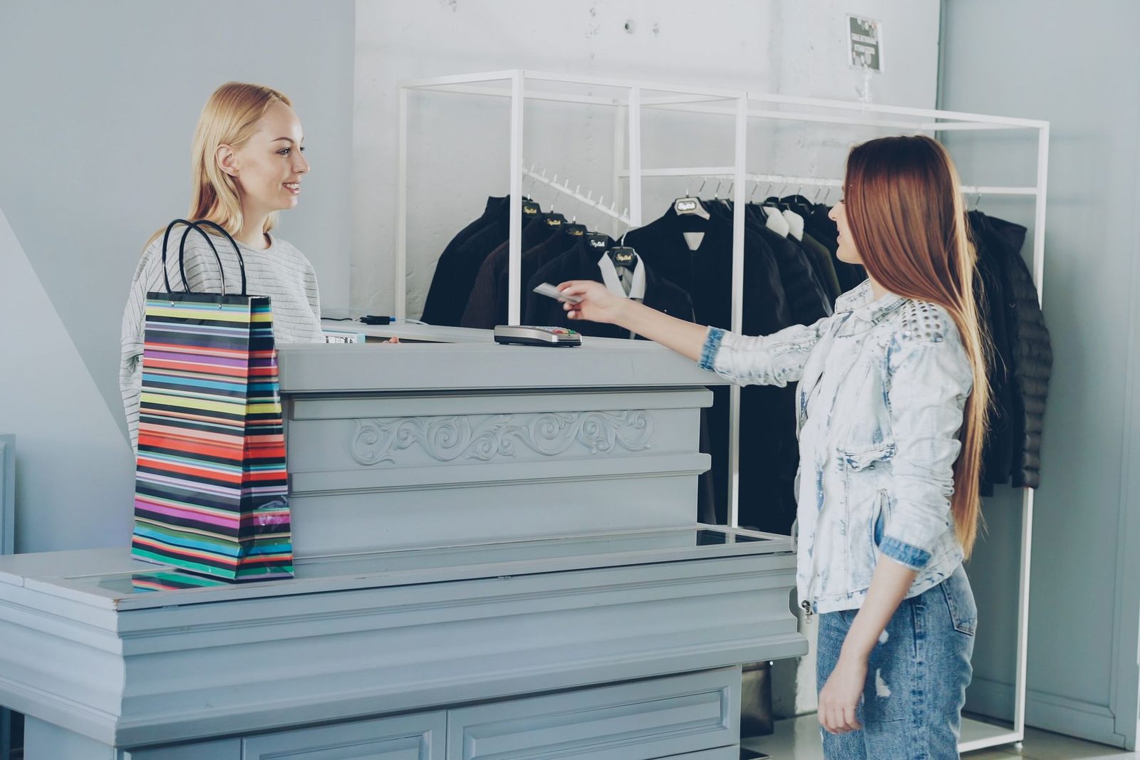 A customer handing over a card at a shop counter