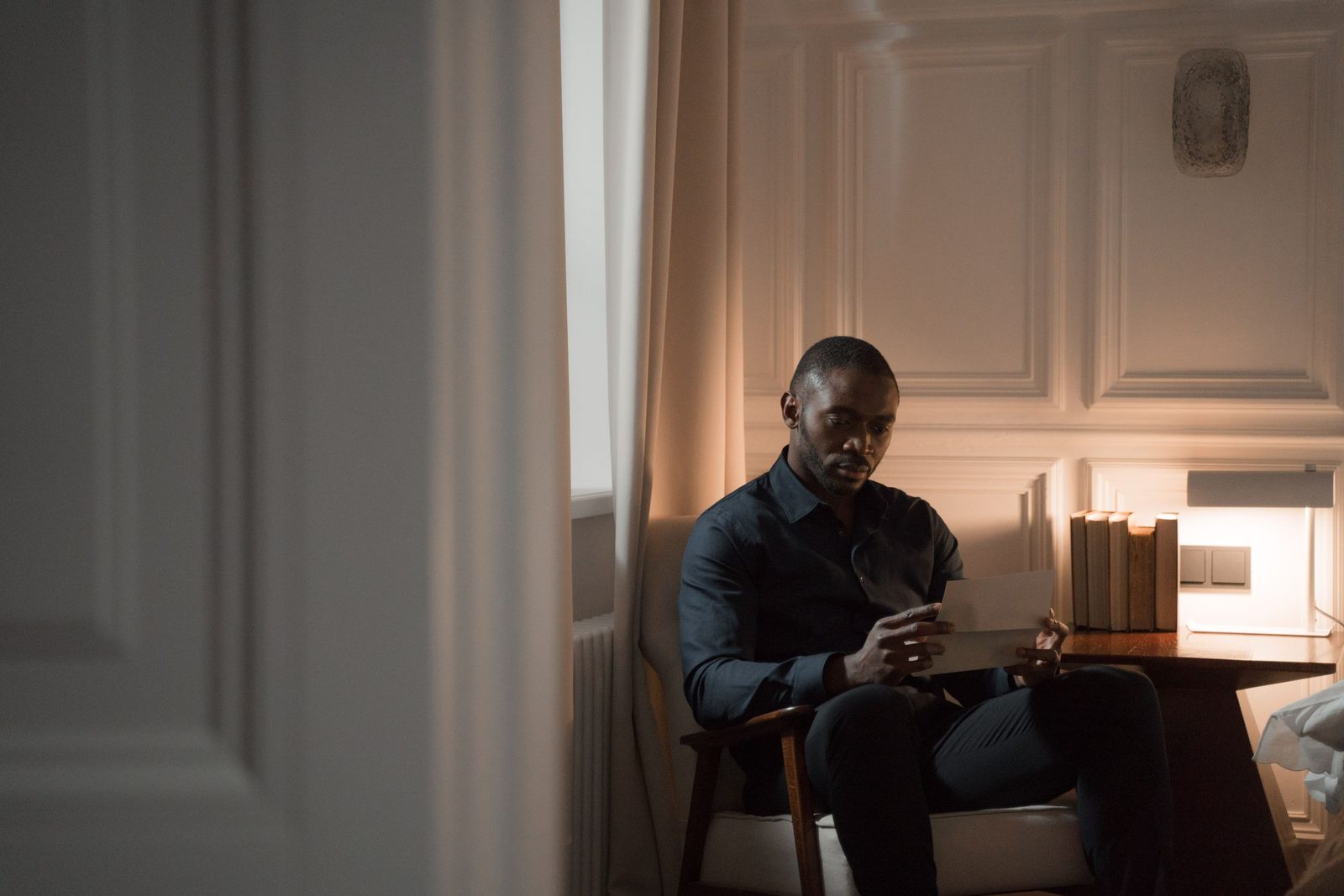 A man reading a letter while sitting at home