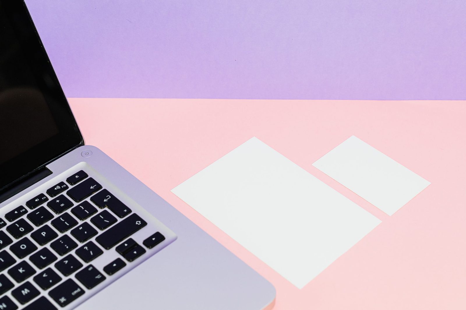 A laptop and blank cards laid out on a desk, ready for a design