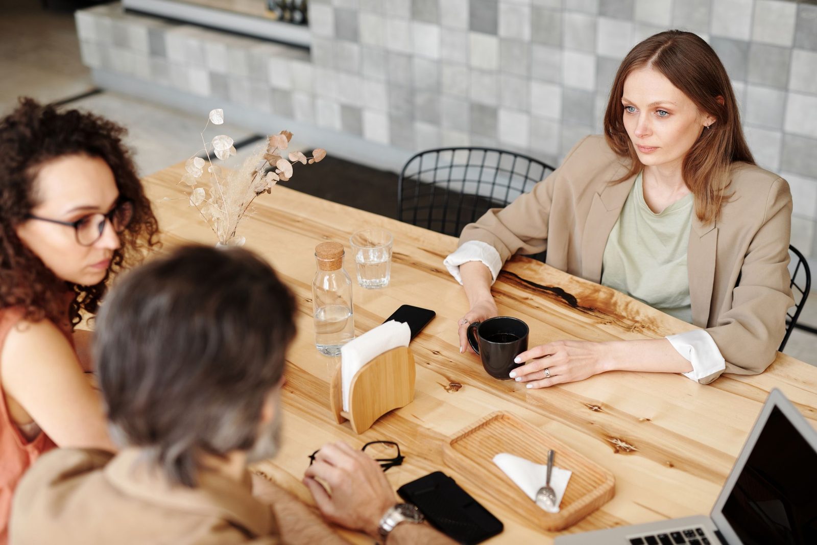 A small team of colleagues talking together around a café table