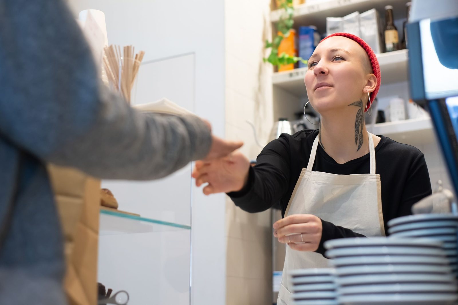A barista serving a customer in a small café