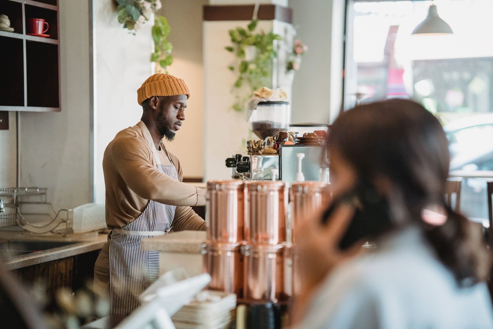 A barista serving a customer in a small café