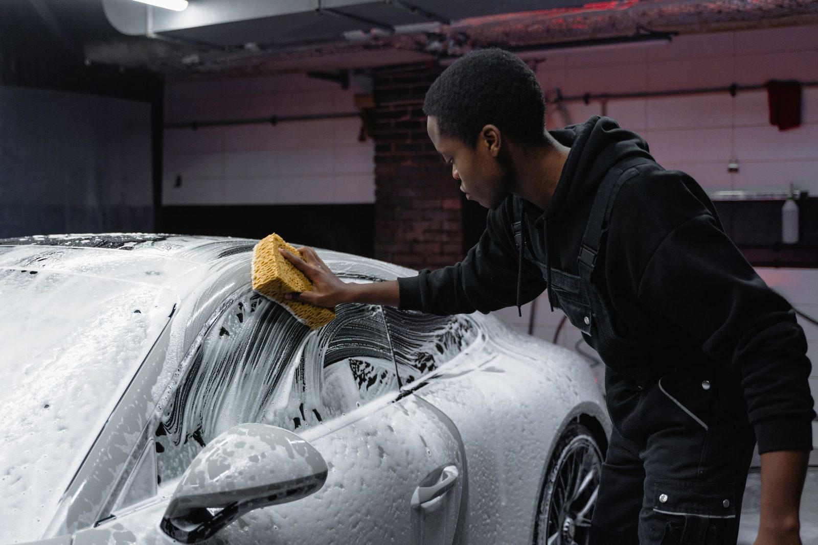 A man washing a car by hand with a sponge
