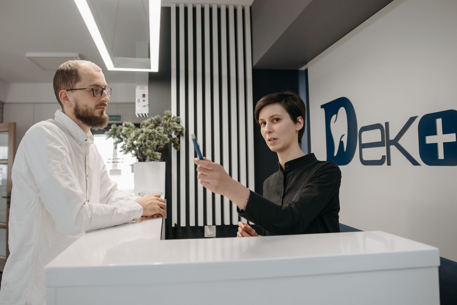 A patient talking to the receptionist at a dental practice
