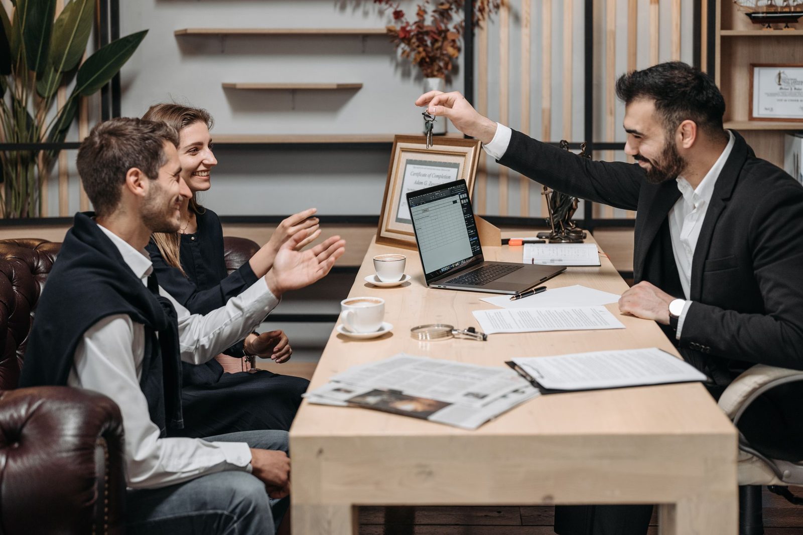 An agent handing keys to a smiling couple