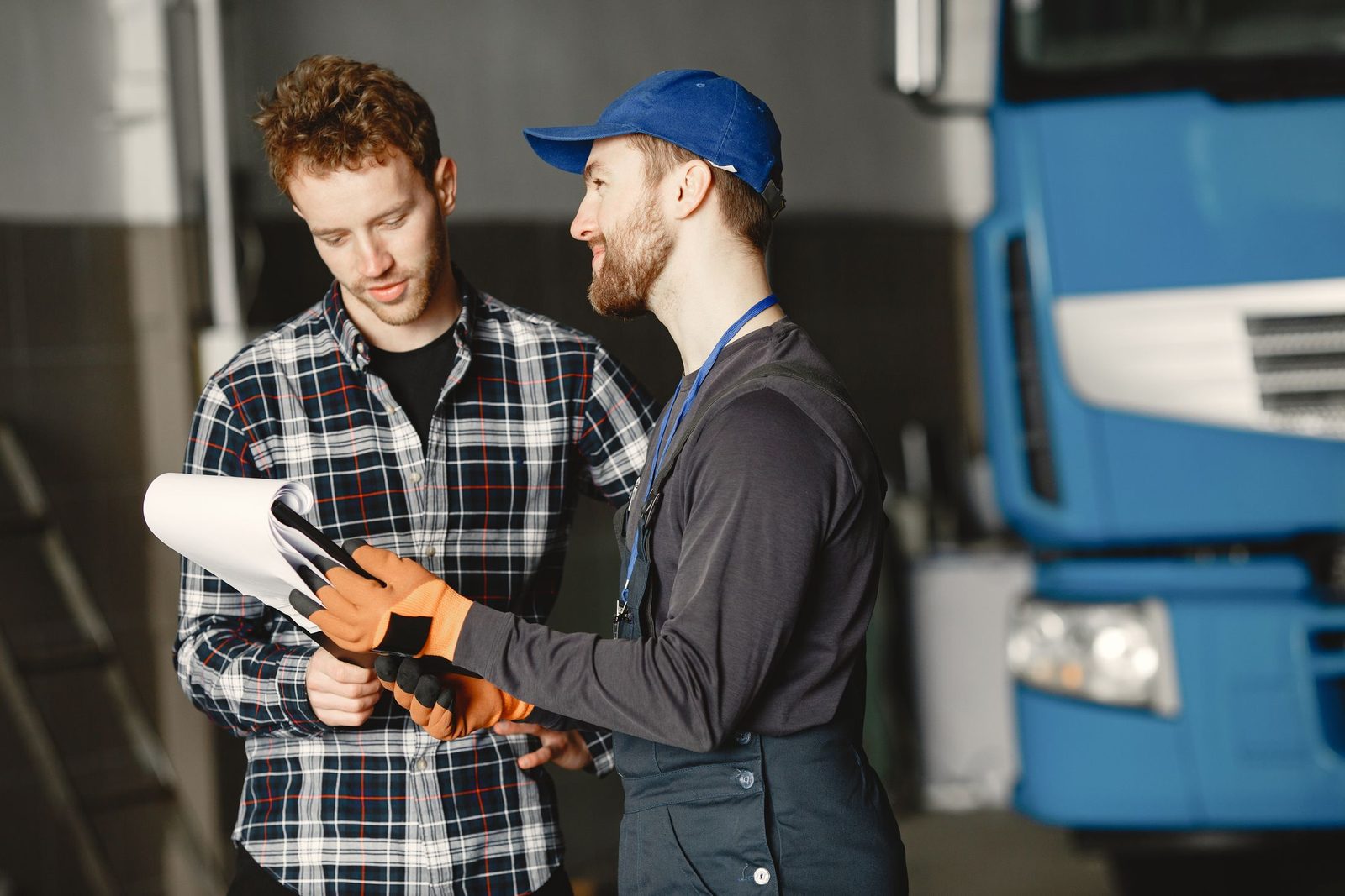 A mechanic talking to a customer in a garage