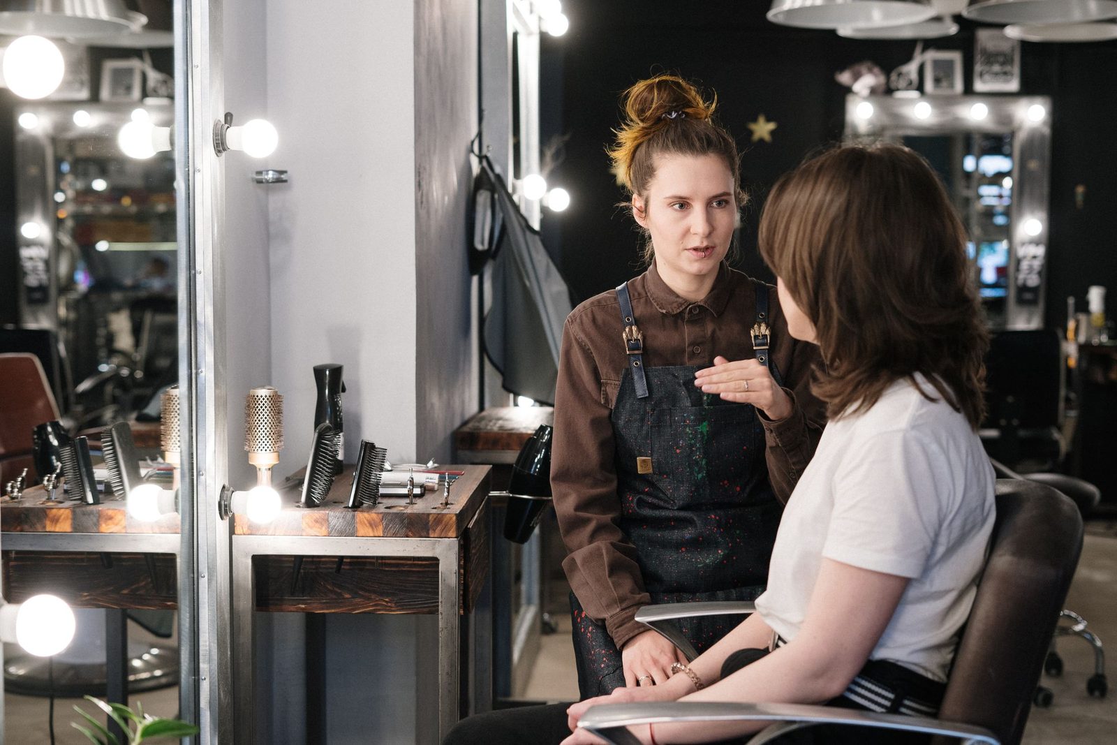 A hairdresser talking a client through her cut in the salon