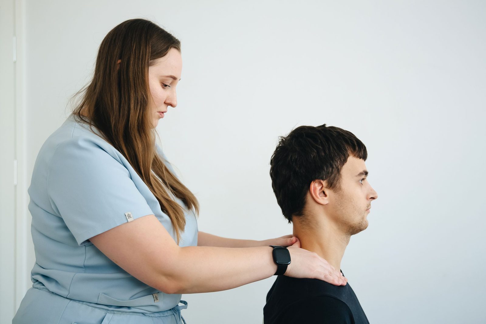 A physiotherapist treating a patient's neck in a clinic