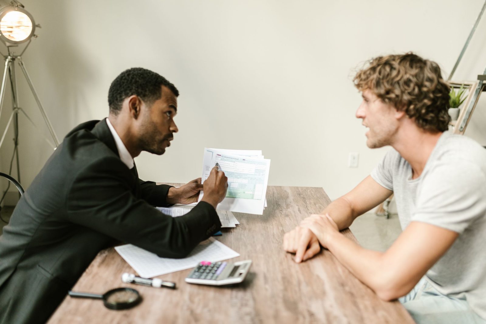An adviser going through paperwork with a client at a desk