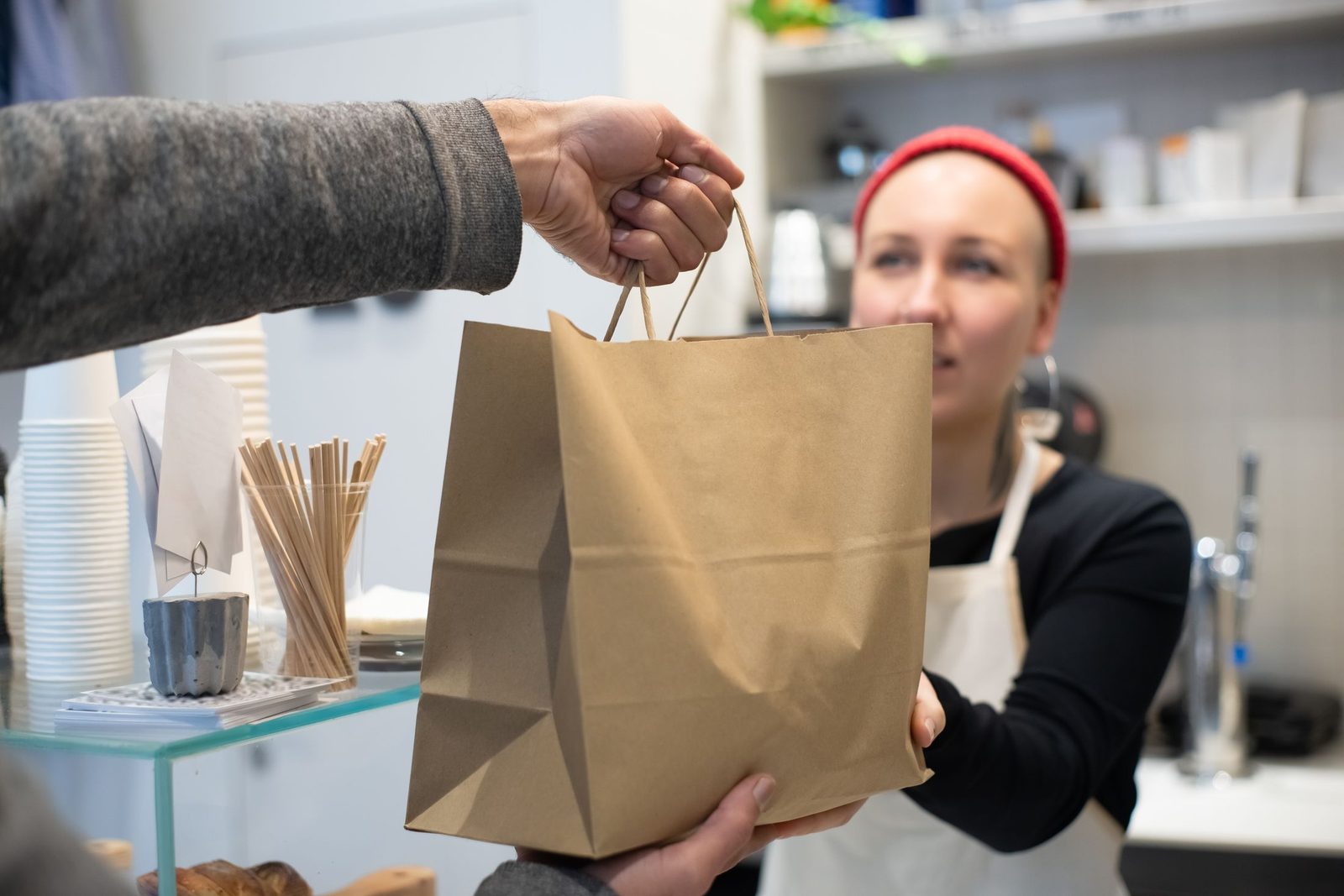 A takeaway bag being handed to a customer over the counter