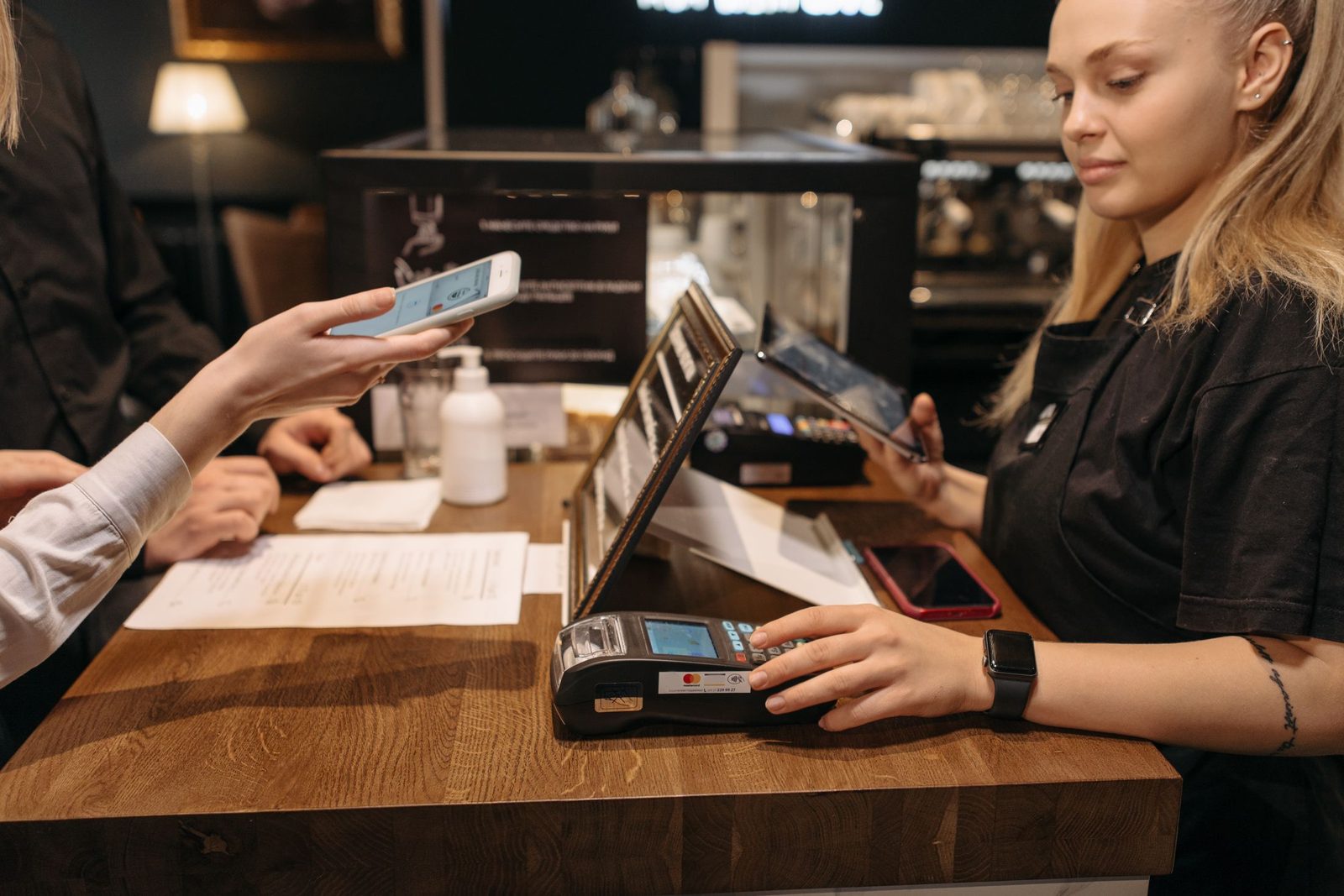 A customer paying by phone at a coffee shop counter