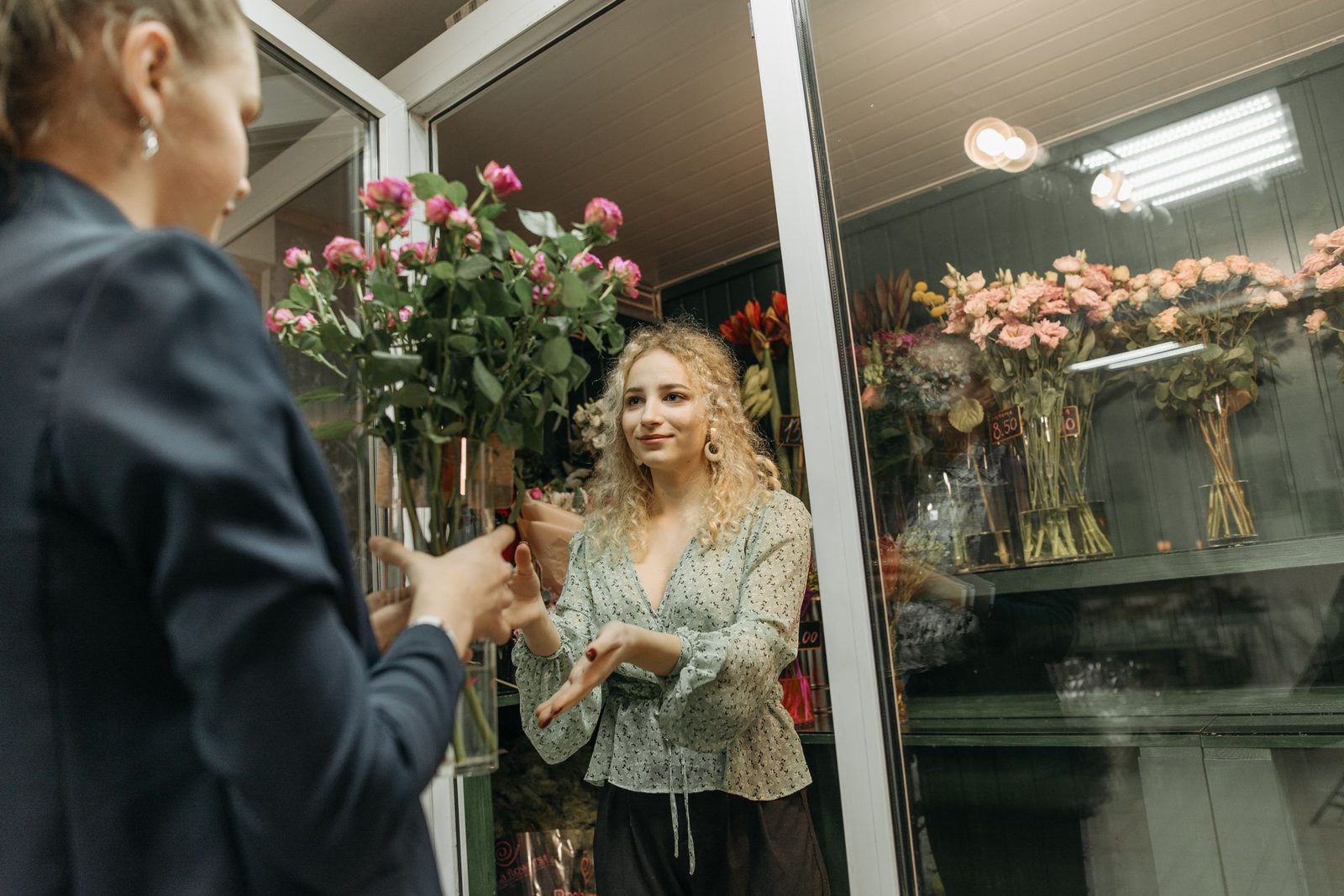 A florist handing a bouquet to a customer