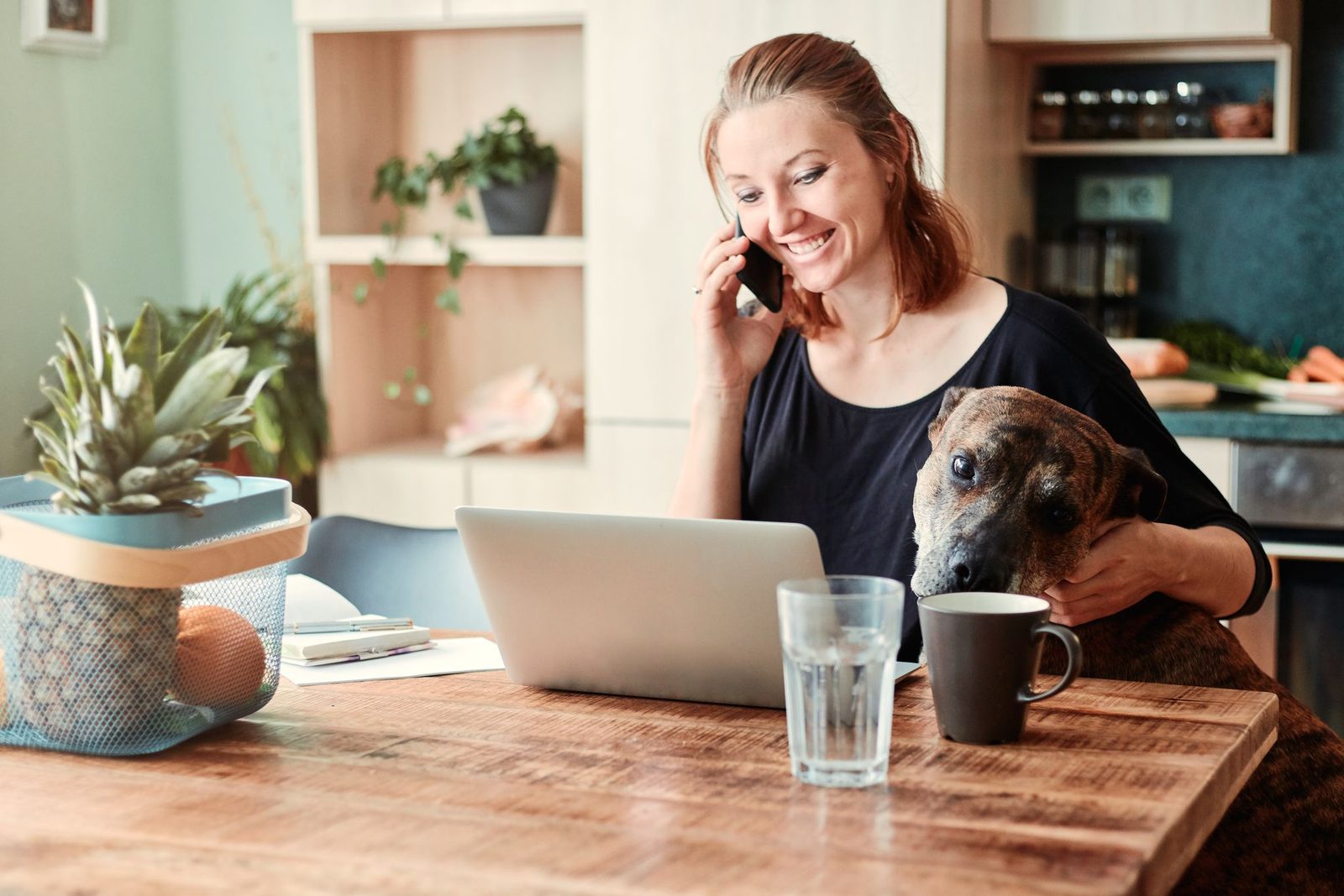 A woman working on a laptop at her kitchen table