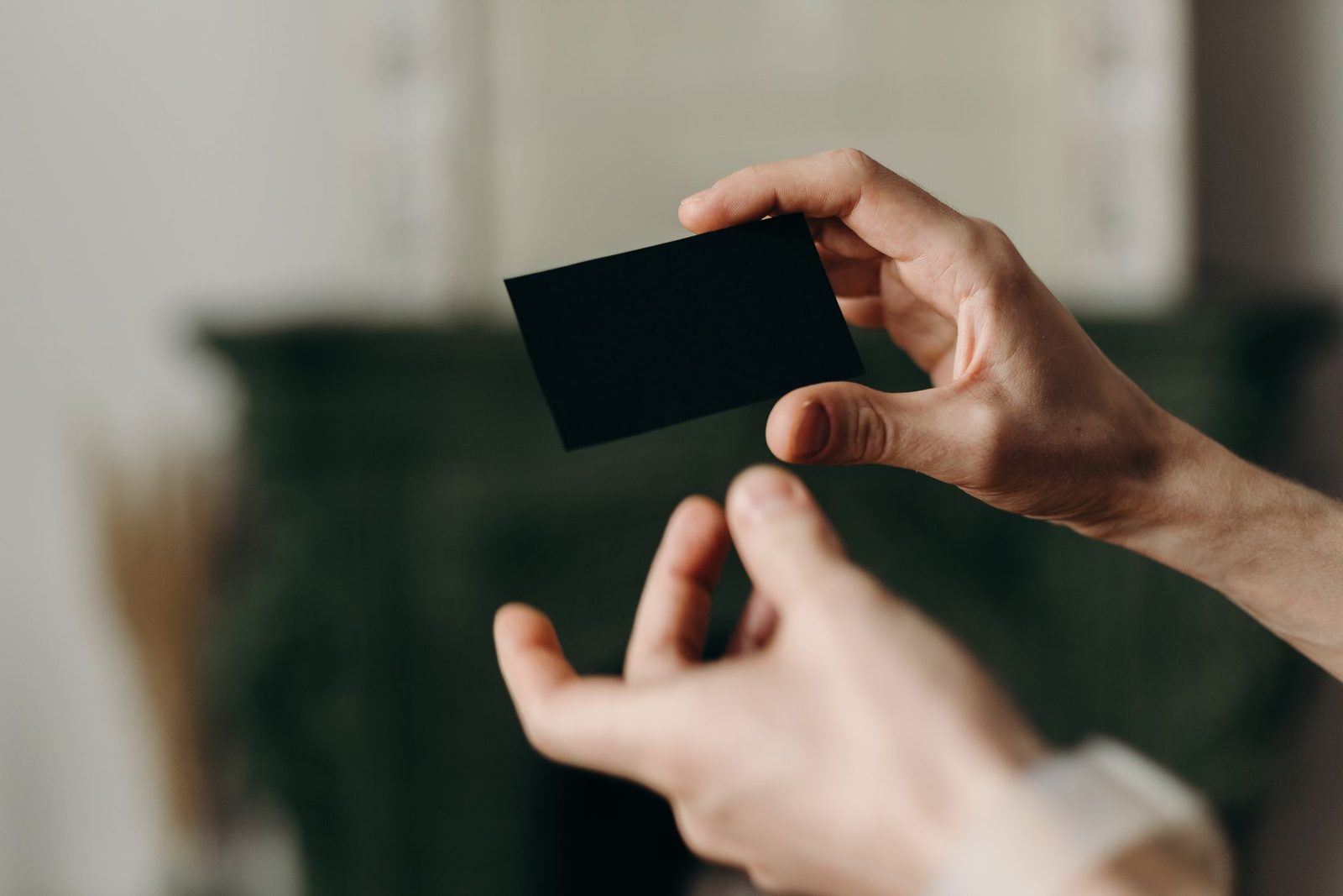 Hands holding a plain black card