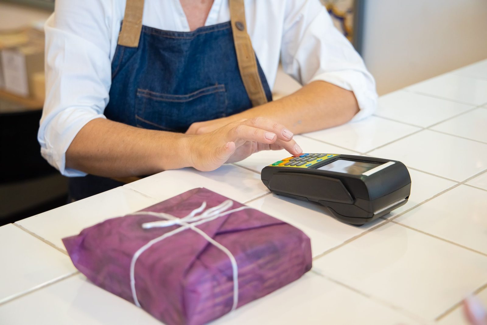 A customer paying contactless at a shop counter
