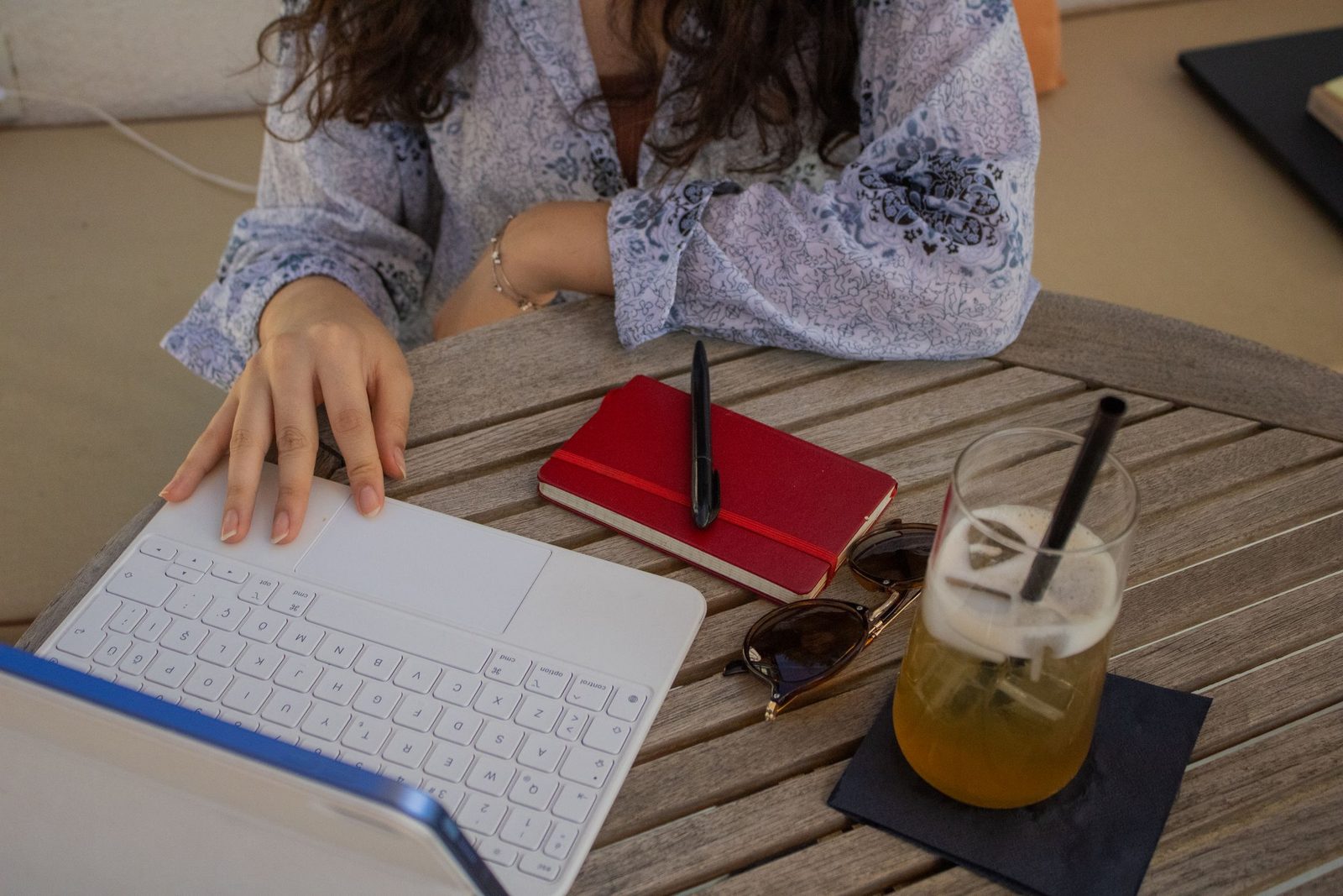A woman working on a laptop at an outdoor café table